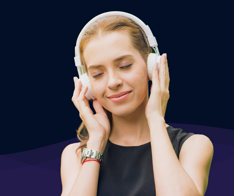 A woman listens to a meditation with headphones on